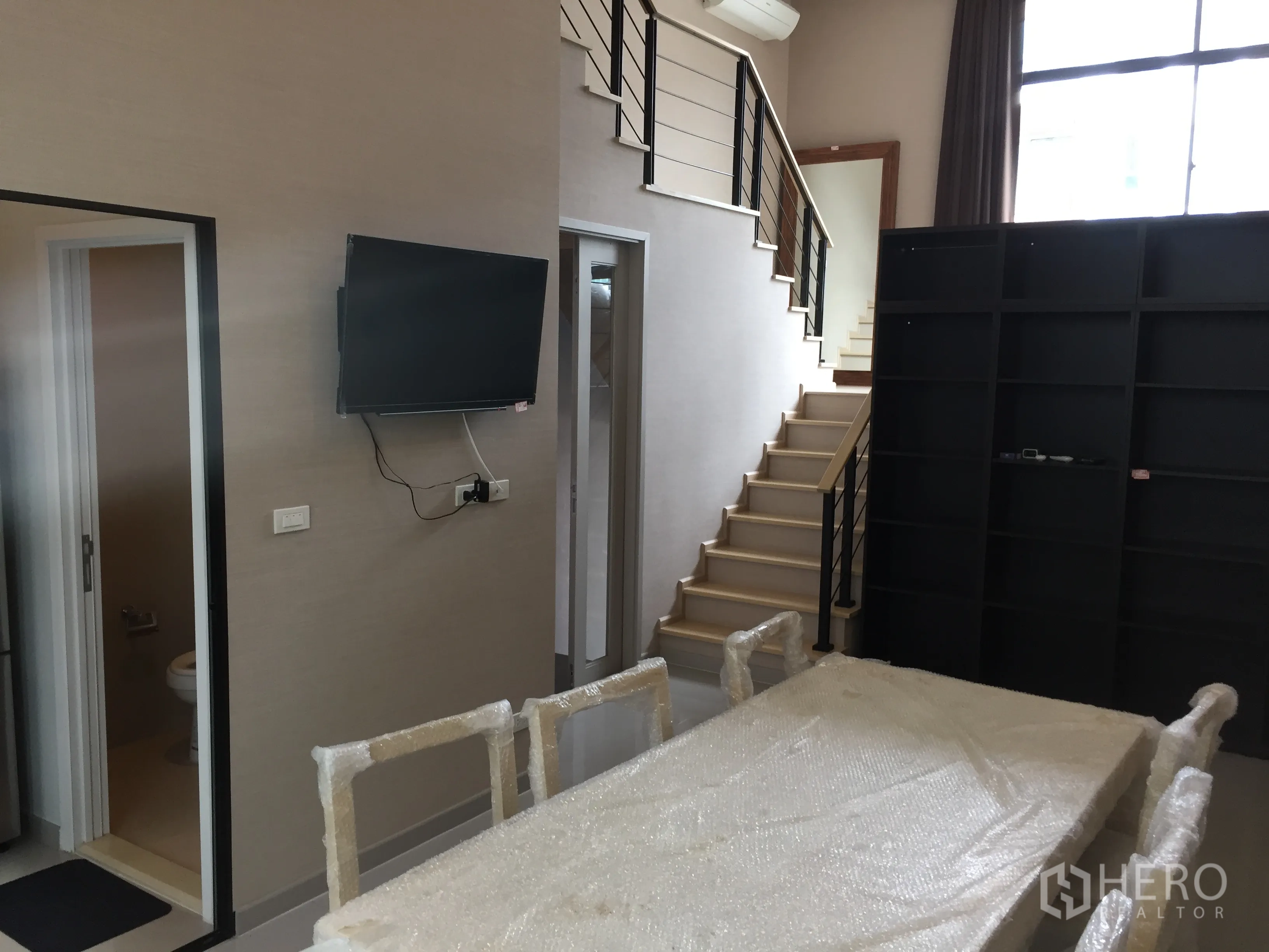 ทาวน์เฮาส์ ให้เช่าในSuan Luang, Bangkok - โซนรับแขกและทานอาหารแบบโอเพ่นแปลน มีบันได ชั้นวาง และห้องน้ำสำหรับแขก