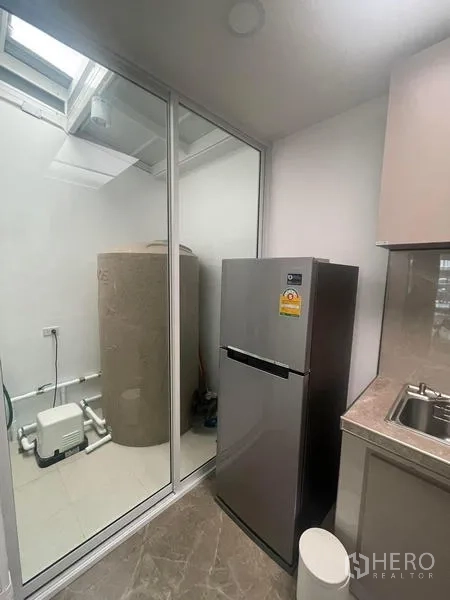 ทาวน์เฮาส์ ให้เช่าในSuan Luang, Bangkok - โซนครัวและซักล้าง ตู้เย็นกั้นด้วยกระจก เห็นแทงก์น้ำภายนอก