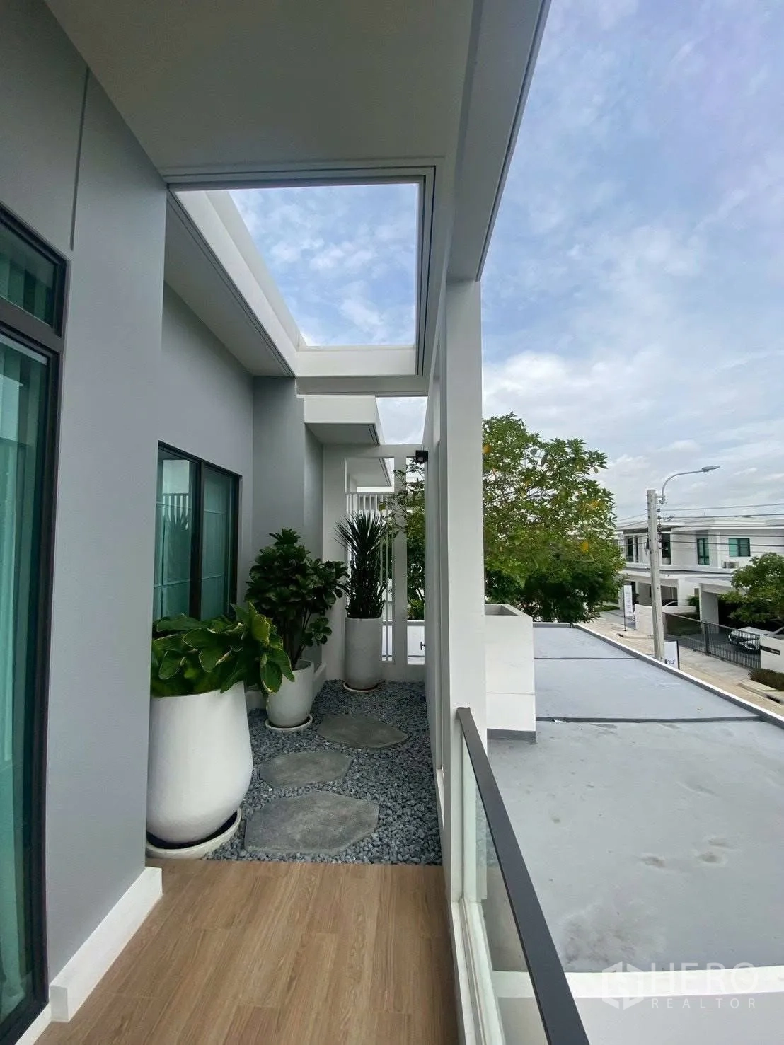 Detached House for rent in Bang Phli, Samut Prakan - Upper-floor balcony with skylight, potted plants and glass railing.