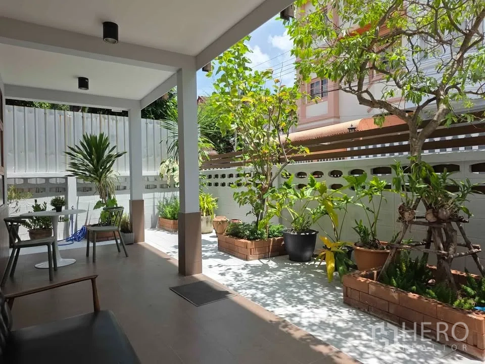 บ้าน ให้เช่าในKhlong Toei, Bangkok - เฉลียงมีหลังคาพักผ่อน พร้อมโต๊ะเก้าอี้ และกระถางต้นไม้เรียงรายในสวน