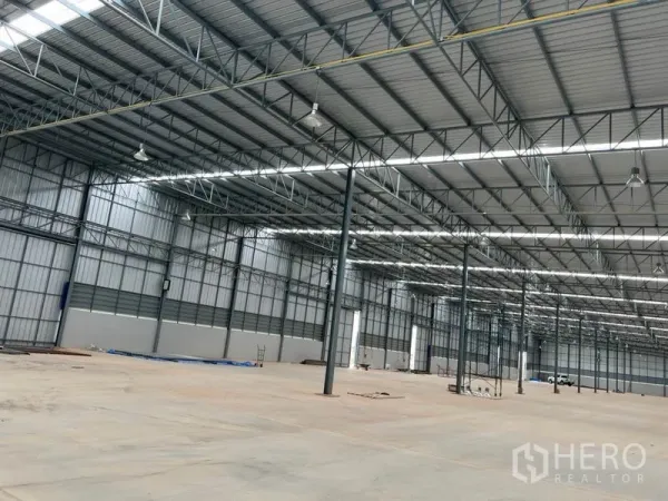 Warehouse for rent in Lat Krabang, Bangkok - Open-plan warehouse showing steel columns, smooth concrete floor, and ample industrial lighting.