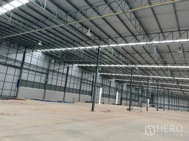 Warehouse for rent in Lat Krabang, Bangkok - Open-plan warehouse showing steel columns, smooth concrete floor, and ample industrial lighting.