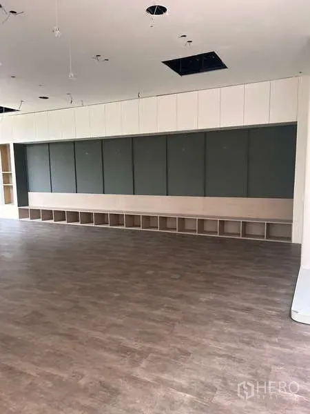 独立商业地产 出租在Khlong Toei, Bangkok - 带内置储物格的展示墙与木纹地面，灵活可改造空间。