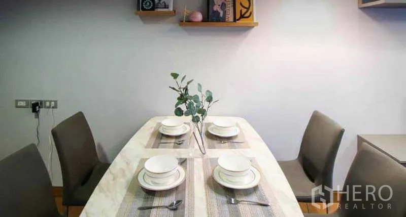 คอนโด ให้เช่าหรือขายในKhlong Toei, Bangkok - ภาพระยะใกล้โต๊ะอาหาร จัดจานช้อนส้อมพร้อมแจกันต้นไม้ และชั้นวางของบนผนัง