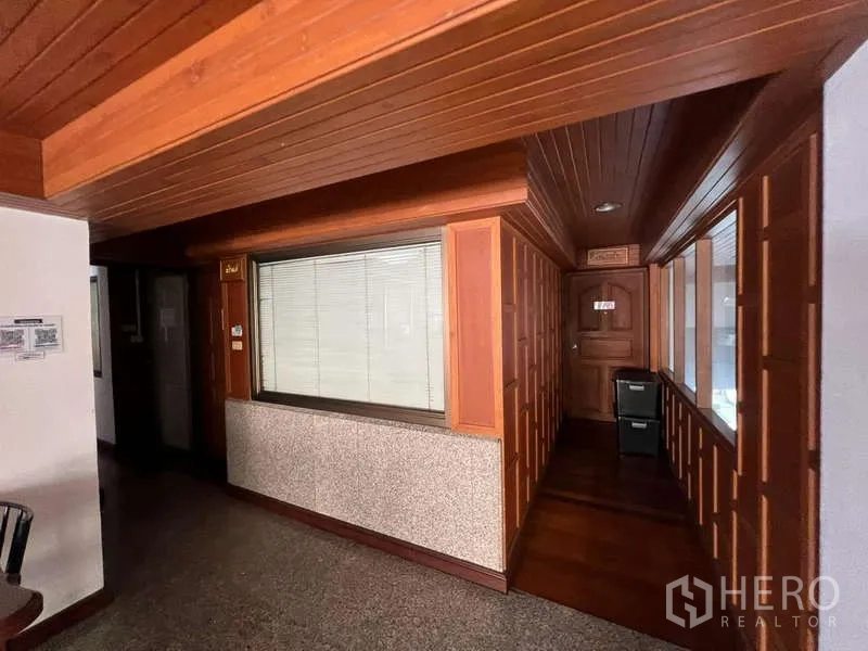 Office Space for rent - Wood-paneled executive office corridor with interior windows.