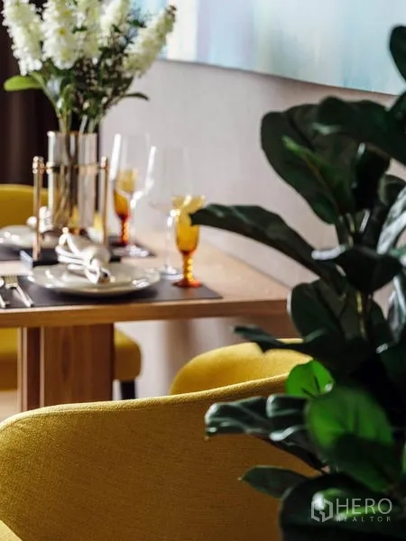 公寓 出租或出售在Bang Rak, Bangkok - 时尚餐区，芥末黄餐椅与前景绿植。
