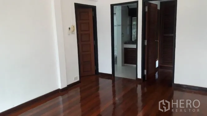 บ้าน ให้เช่าในYan Nawa, Bangkok - ห้องนอนพื้นไม้ขัดเงา ผนังสีขาว มีประตูเชื่อมเข้าห้องน้ำและตู้เสื้อผ้า