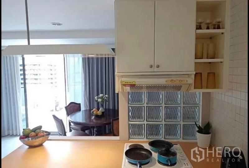 คอนโด ให้เช่าหรือขายในKhlong Toei, Bangkok - พื้นที่เตาและเครื่องดูดควัน ข้างผนังกระจกบล็อก มองเห็นโซนรับประทานอาหาร