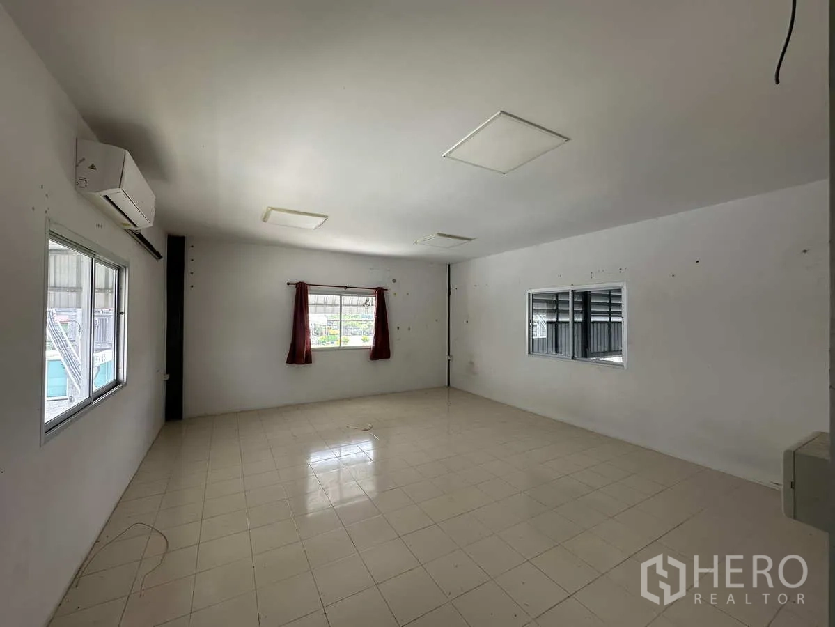 Factory for rent in Pathum Thani - Second office space with windows, air-conditioning units and natural light.