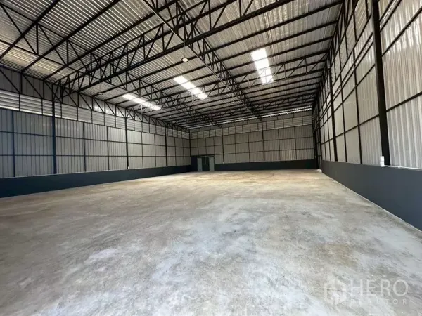 Warehouse for rent in Wang Thonglang, Bangkok - Open warehouse hall showing tall ceilings, metal cladding walls and a large unobstructed floor area.