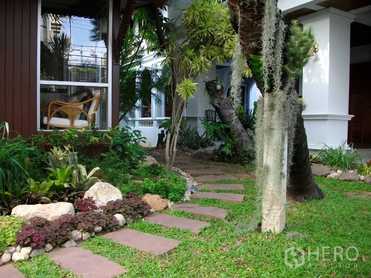 บ้าน ให้เช่าในKhlong Toei, Bangkok - ลานหน้าบ้านเขียวชอุ่ม ทางเดินหิน พืชเมืองร้อน และมุมนั่งเล่นริมหน้าต่างบานกว้าง.