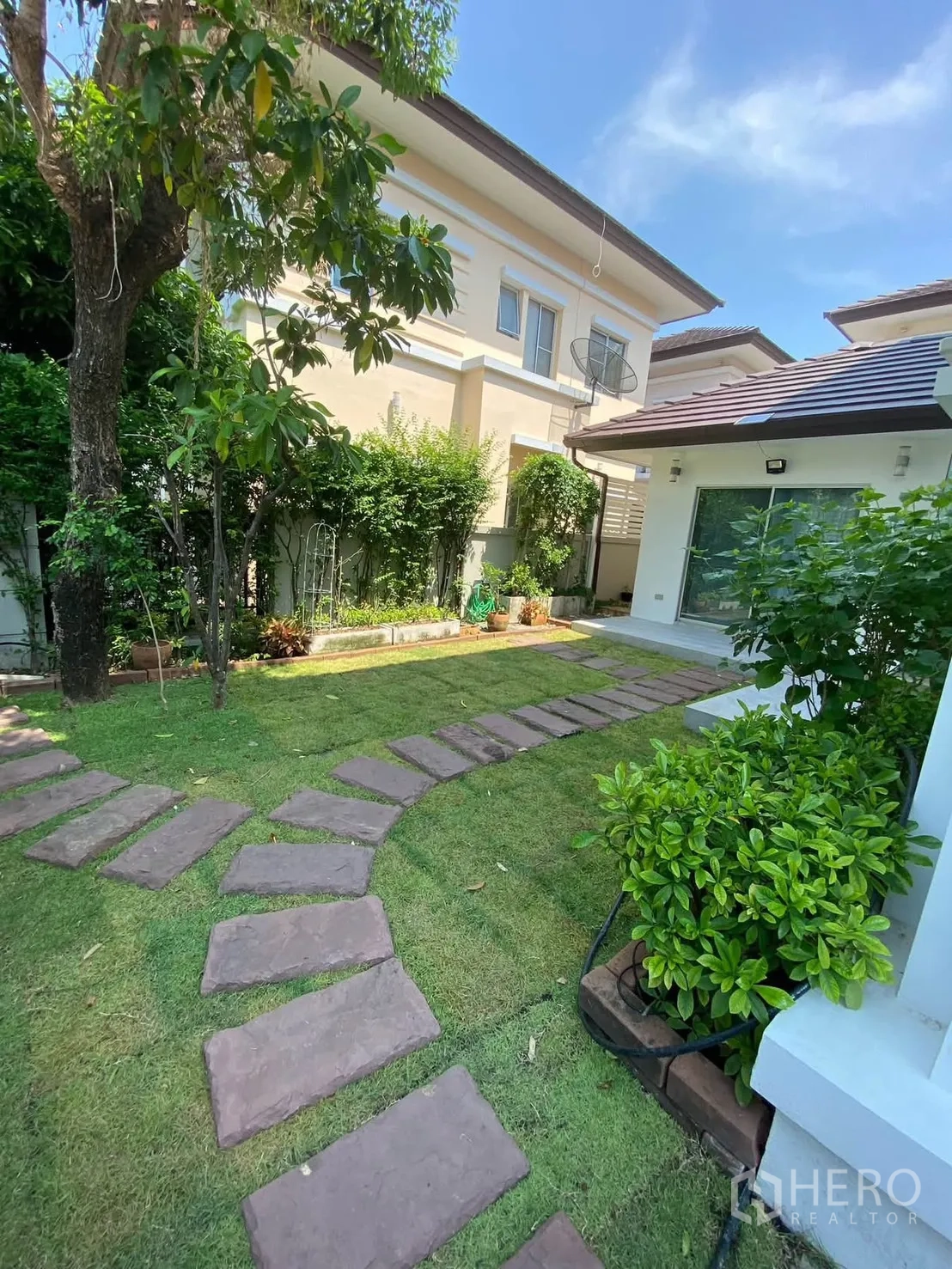 Detached House for rent in Mueang Samut Prakan, Samut Prakan - Curved stone path across a lush private garden with mature trees.