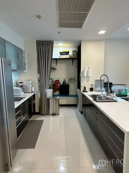 Condominium for rent in Yan Nawa, Bangkok - Built-in kitchen with appliances, double-door fridge, and laundry nook.
