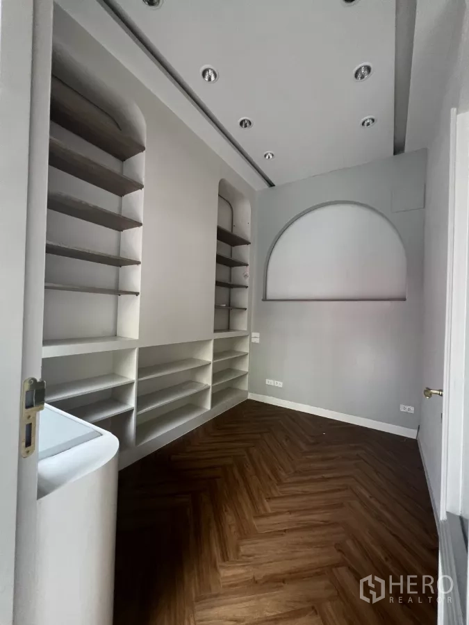 零售空间 出租在Watthana, Bangkok - 小型零售室内，内置展示层架、筒灯与人字拼木纹地板。