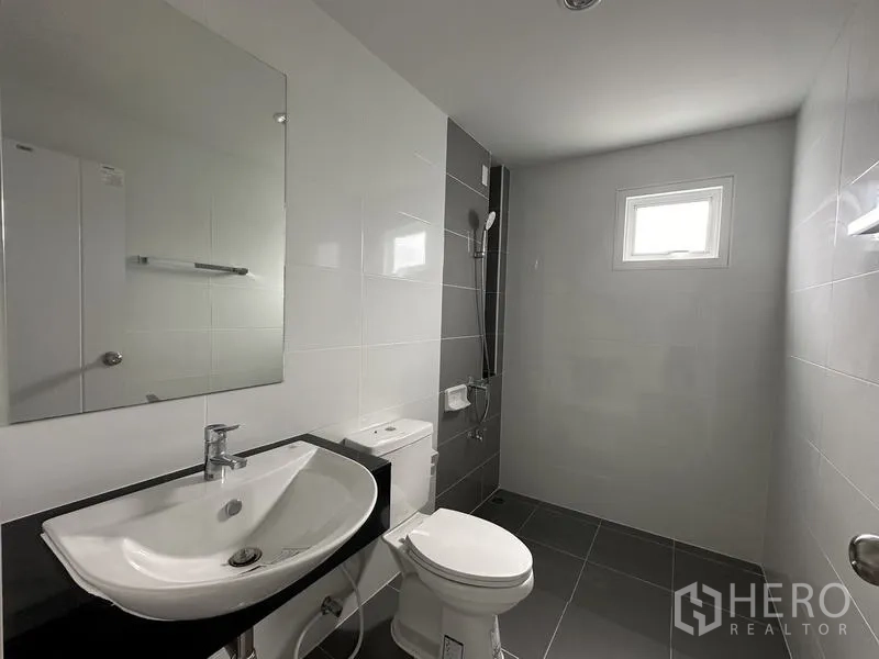 บ้าน ขายในLam Luk Ka, Pathum Thani - ห้องน้ำพื้นกระเบื้องสีเทา โซนอาบน้ำและหน้าต่างบานเล็ก