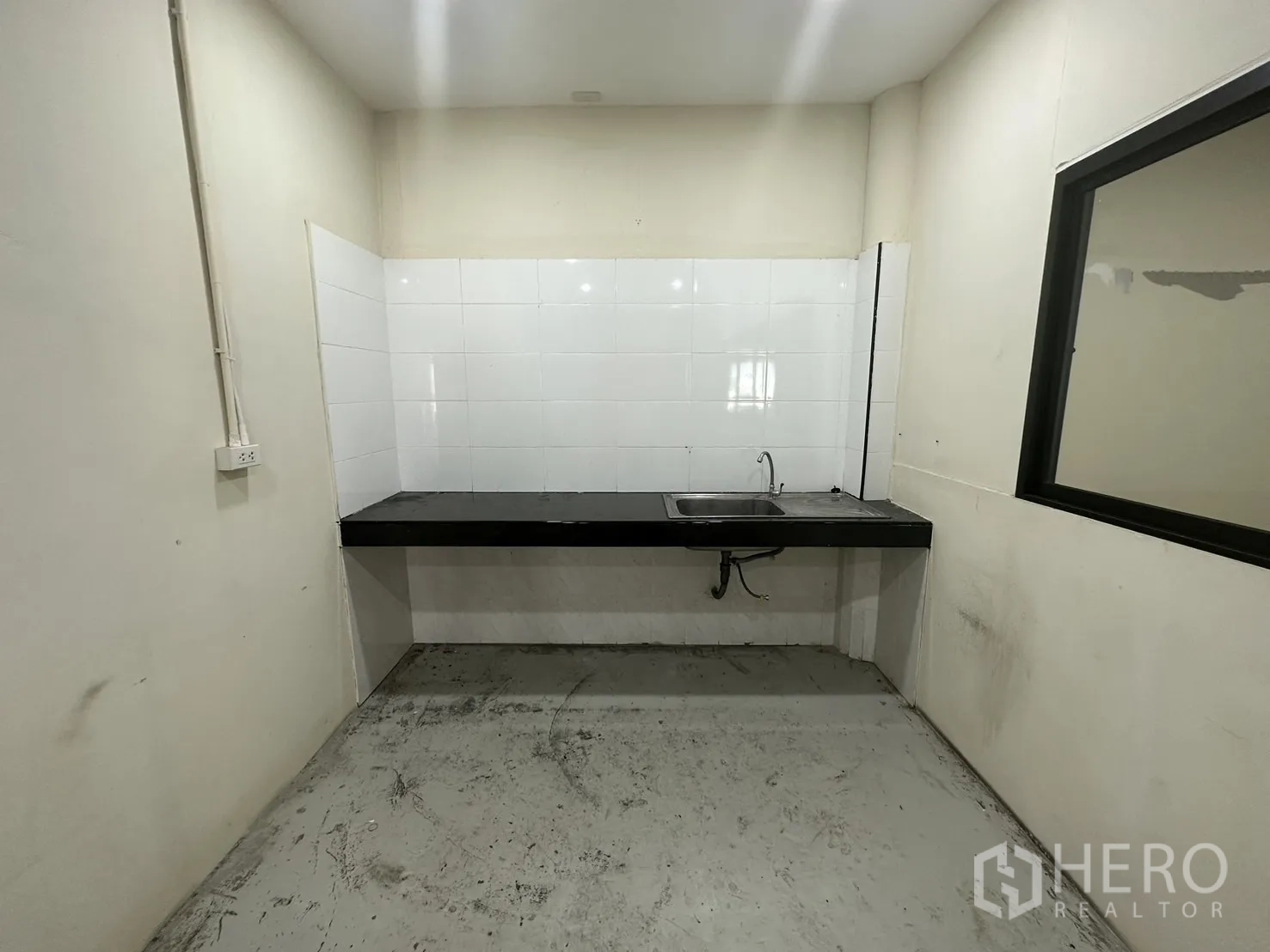 货栈 出租在Suan Luang, Bangkok - 茶水间，带水槽、黑色台面与白色瓷砖背墙。