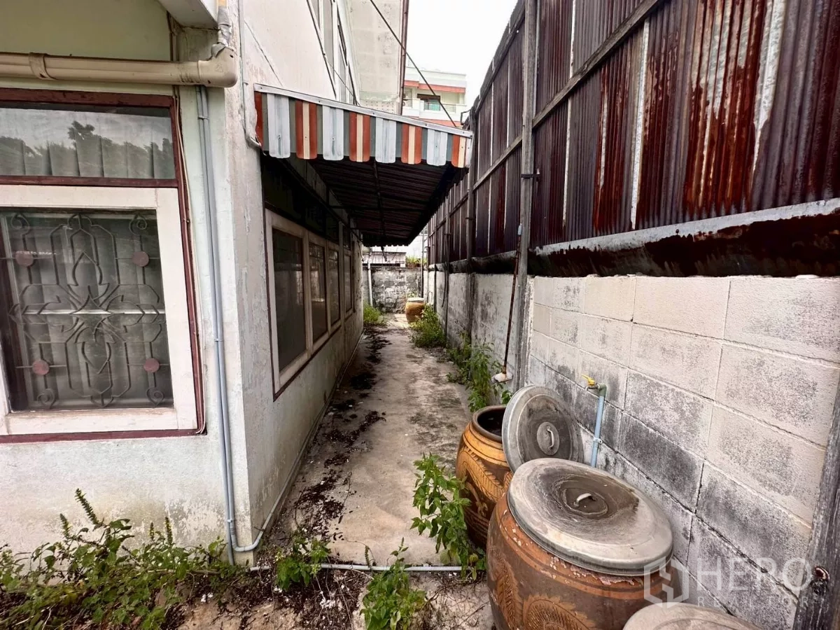 零售空间 出租在Khlong Toei, Bangkok - 侧边狭长通道，遮篷、陶缸与水泥墙