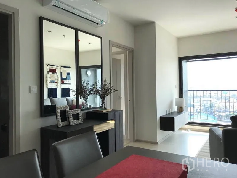 คอนโด ให้เช่าในKhlong Toei, Bangkok - พื้นที่นั่งเล่นสว่างพร้อมโต๊ะทานอาหาร กระจกเงาบานใหญ่ และระเบียงวิวเมืองที่ Life Condominium