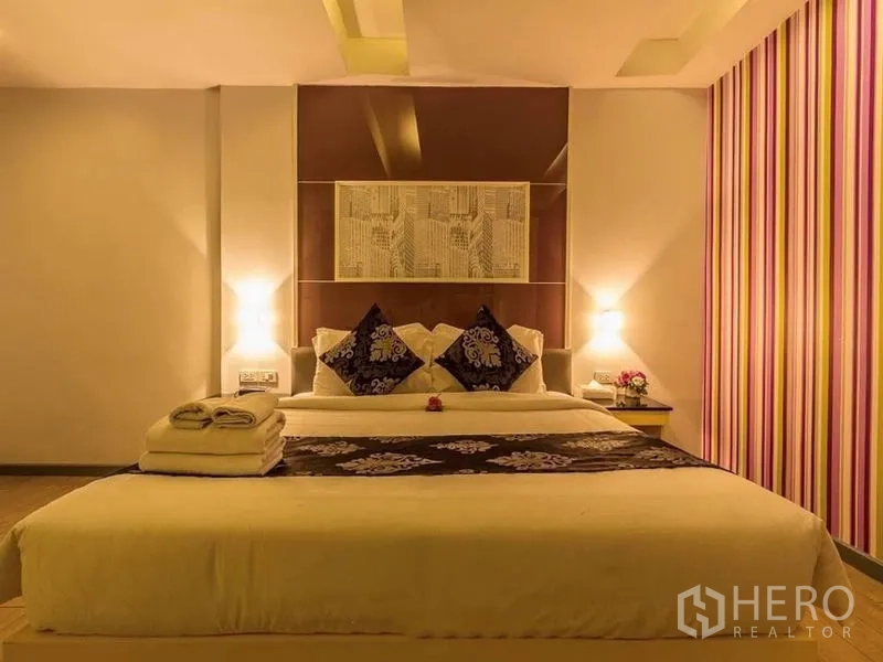 อาคารพาณิชย์ ให้เช่าหรือขายในKhlong Toei, Bangkok - ห้องนอนคิงไซส์กว้างขวาง ผนังลายทาง โคมไฟหัวเตียง และชุดผ้าเครื่องนอน