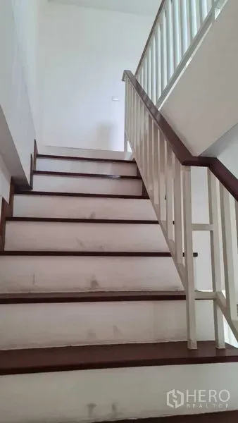 联排别墅 for 在Lam Luk Ka, Pathum Thani - 室内楼梯，木质台阶与白色栏杆。