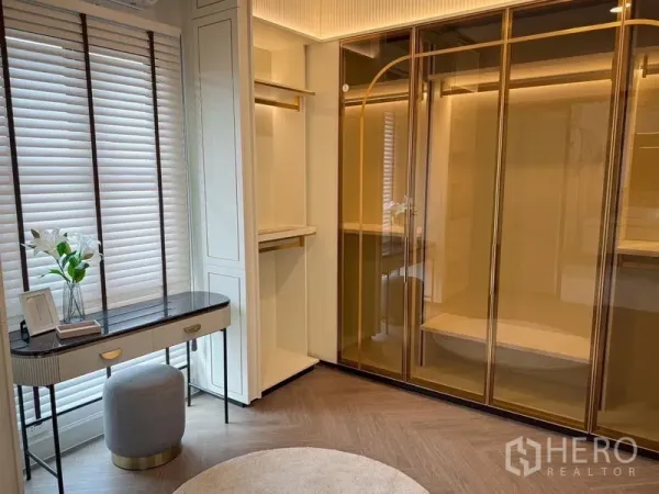 独立式住宅 出租或出售 - 步入式衣帽间，玻璃柜门衣柜与窗边妆台。