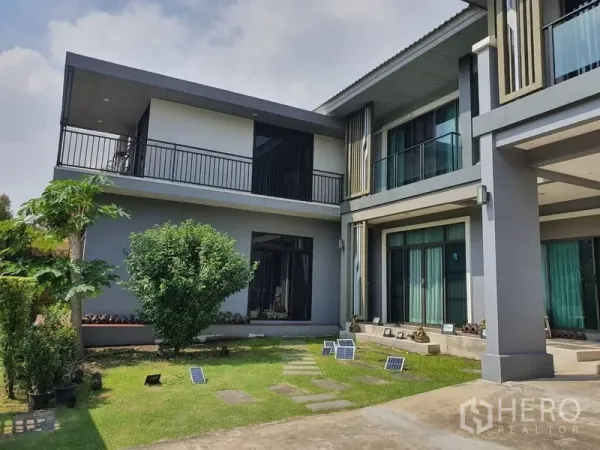 Detached House for sale in Suan Luang, Bangkok - Private lawn courtyard between two wings of the house with sliding glass doors and wraparound balcony.