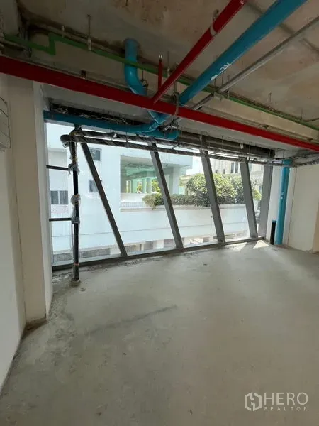 零售空间 出租在Pathum Wan, Bangkok - 毛坯零售单元，倾斜窗与外露管线一览无余。