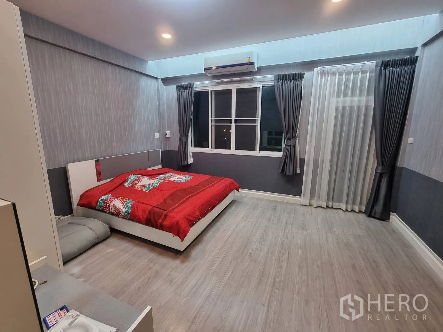 Townhouse for rent in Din Daeng, Bangkok - Spacious bedroom with double bed, gray walls, curtains and window with AC.