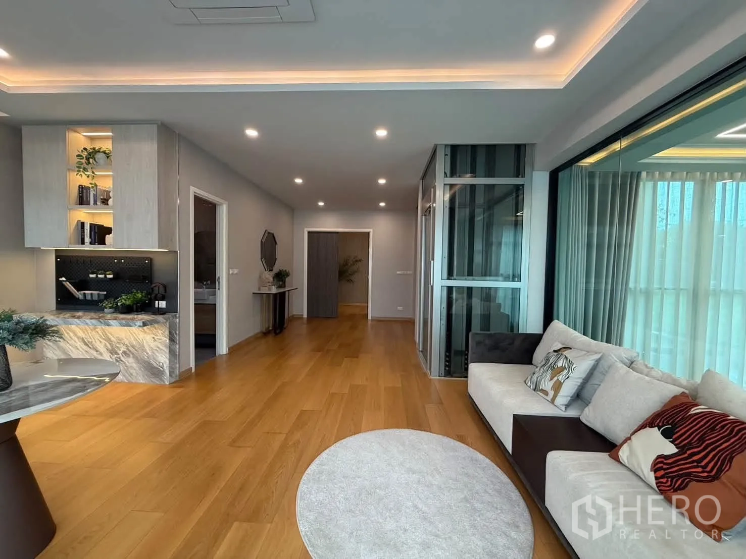 独栋房屋 for rent in Suan Luang, Bangkok - 家庭客厅配沙发、灯槽天花与玻璃电梯。