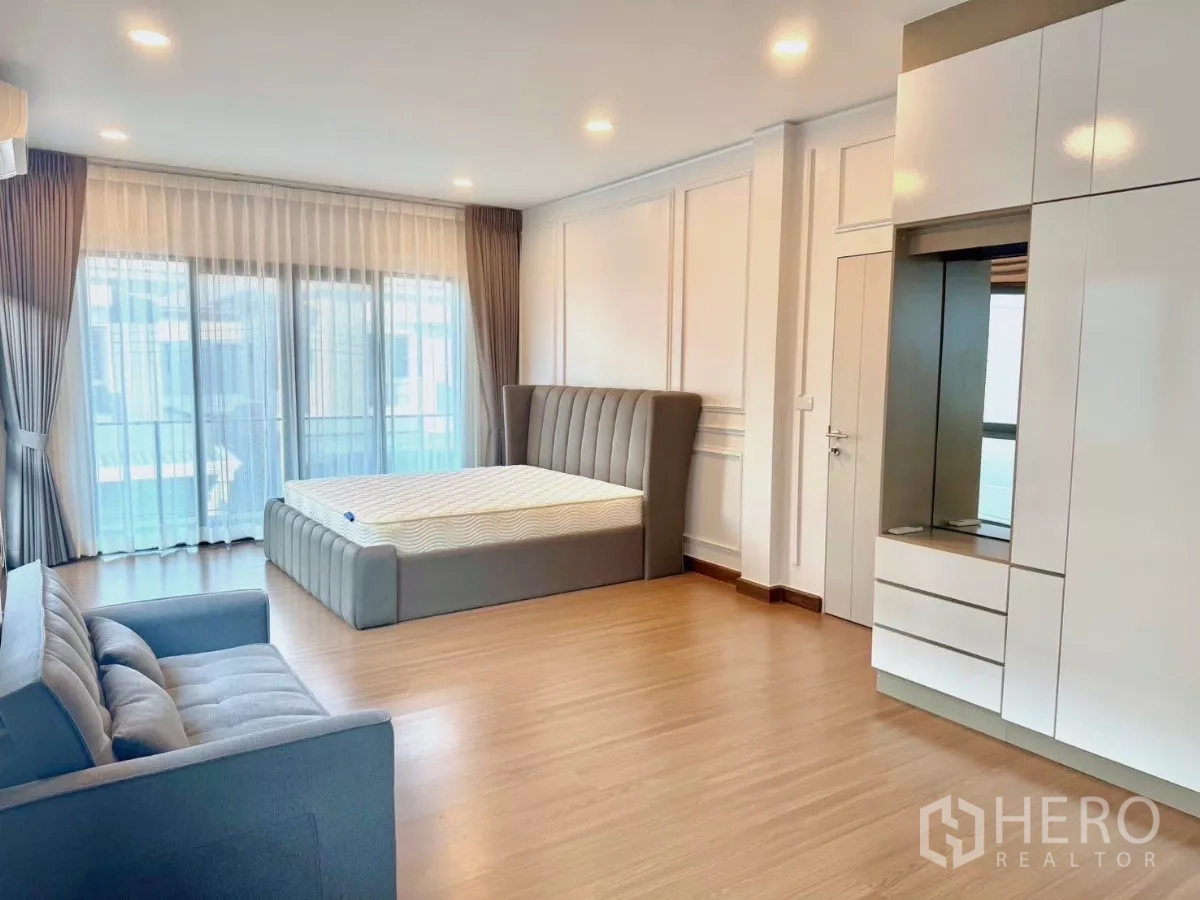 Detached House for rent in Bang Phli, Samut Prakan - Spacious master bedroom with floor-to-ceiling windows, a sofa and built-in wardrobe.