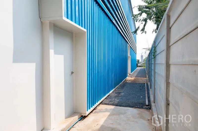คลังสินค้า ให้เช่าในKhlong Luang, Pathum Thani - ทางเดินบริการข้างอาคารระหว่างผนังโกดังกับรั้วคอนกรีต มีประตูทางออก