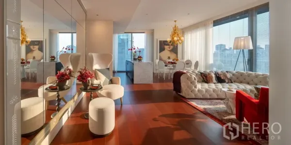 Condominium for sale in Watthana, Bangkok - Wide view of elegant lounge and dining area with mirrors, tufted sofa and city‑view glazing.