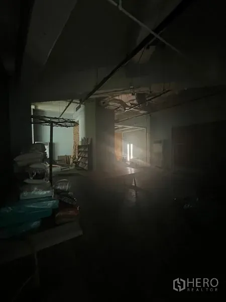 零售空间 出租在Khlong Toei, Bangkok - 未完成的室内空间，裸露天花、储物架，门口透入一束光。