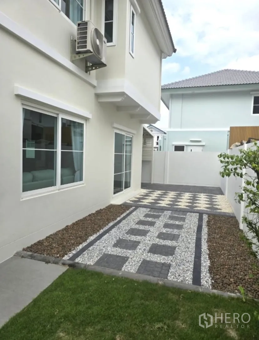 Detached House for rent in Bang Phli, Samut Prakan - Rear side yard with gravel and paver paths next to a small lawn.