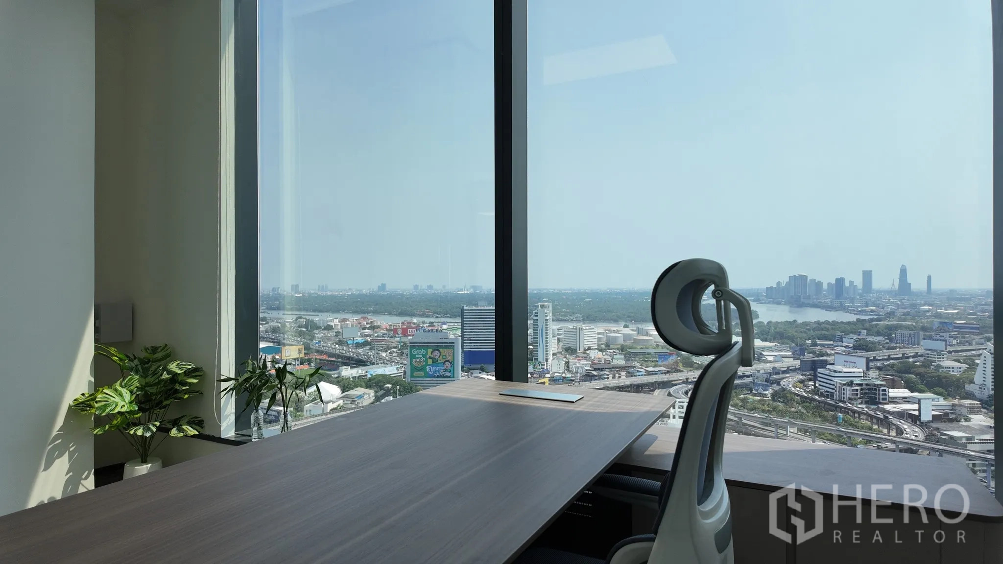 Office Space for rent in Khlong Toei, Bangkok - Executive corner desk by floor-to-ceiling windows with a wide view over the city.