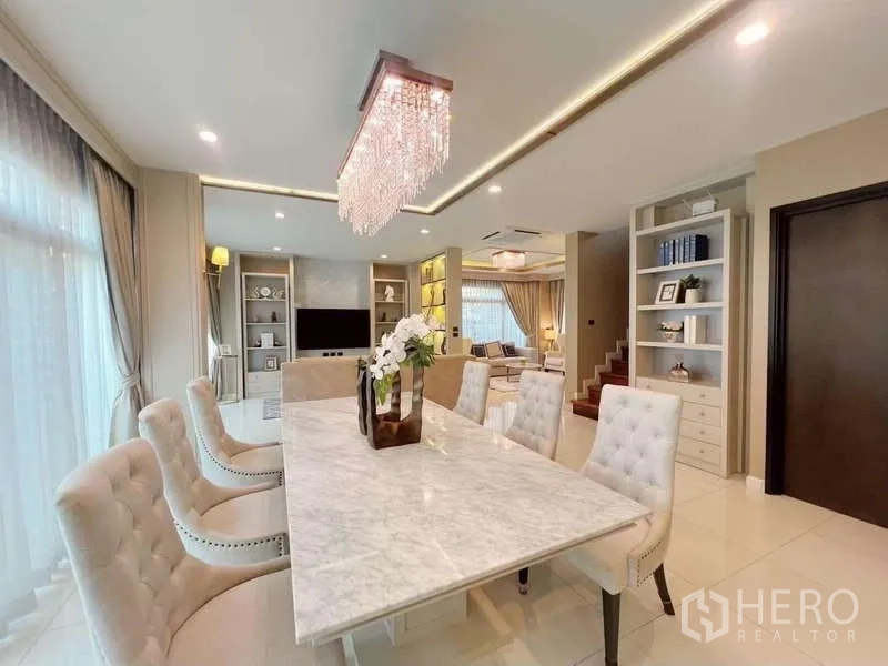 Detached House for rent or sale in Bang Phli, Samut Prakan - Dining area with marble table, crystal chandelier and floor-to-ceiling windows.