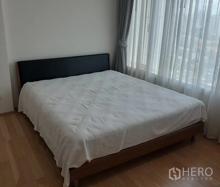 คอนโด ให้เช่าในKhlong Toei, Bangkok - ห้องนอนมุมกว้าง เตียงขนาดใหญ่ หน้าต่างบานใหญ่ ผ้าม่านสีเทา พร้อมวิวเมือง