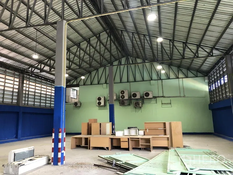 Warehouse for rent in Sai Mai, Bangkok - Warehouse area with multiple wall-mounted air conditioners and storage materials.