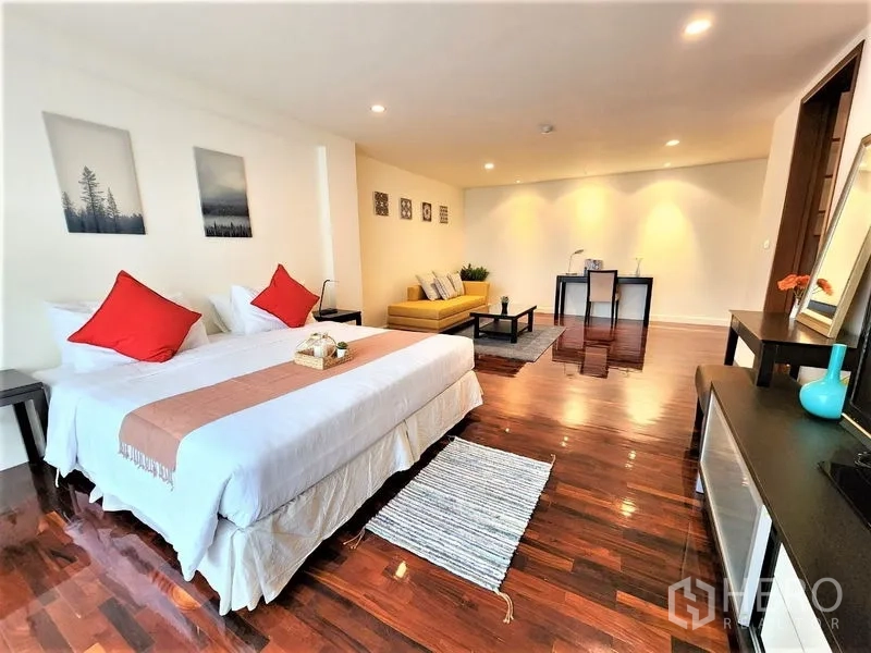 Condominium for rent in Bang Rak, Bangkok - Oversized master suite with king bed, sitting area, sofa and work desk on glossy wood floors.