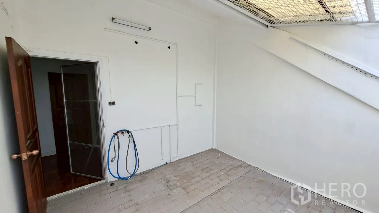 Townhouse for rent in Watthana, Bangkok - Rooftop terrace with mesh canopy allowing open-air light and views.