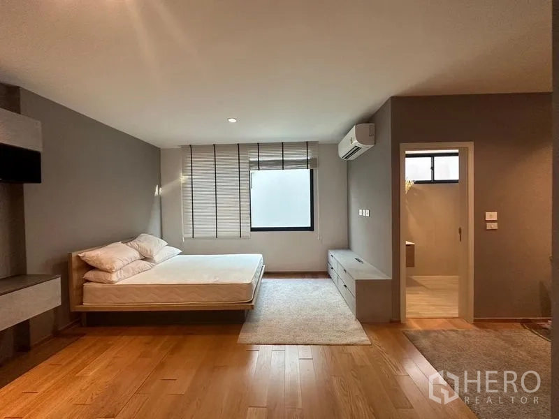 ทาวน์เฮาส์ ขายในSaphan Sung, Bangkok - ห้องนอนใหญ่พร้อมพื้นไม้ เครื่องปรับอากาศ และประตูเข้าสู่ห้องน้ำ