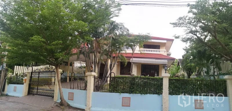 独立式住宅 出售 - 街景视角，铁艺围栏后被绿树环绕的独栋住宅。