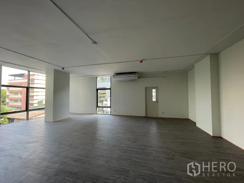 Office Space for rent in Bang Rak, Bangkok - Open room view with wall-mounted AC unit and tall side window.