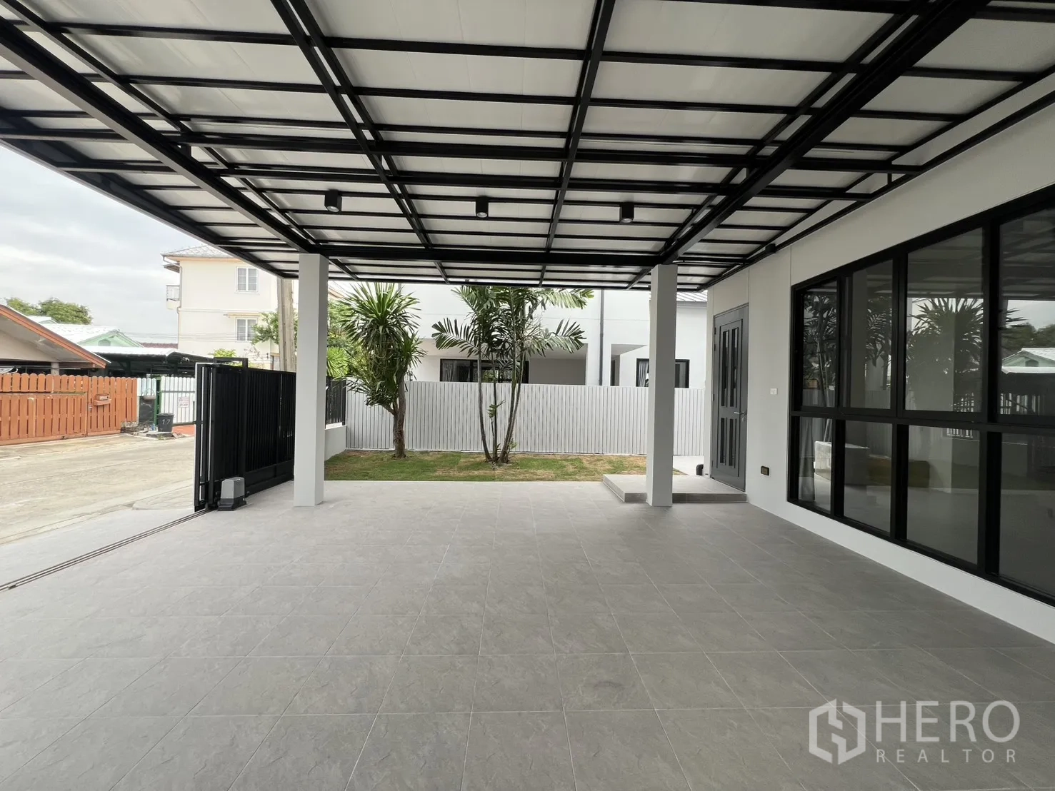 Detached House for rent in Saphan Sung, Bangkok - Covered parking opening to street with black gate and fence.