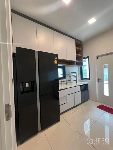 Detached House for rent or sale - Kitchen with double-door refrigerator, upper cabinets and marble counters.