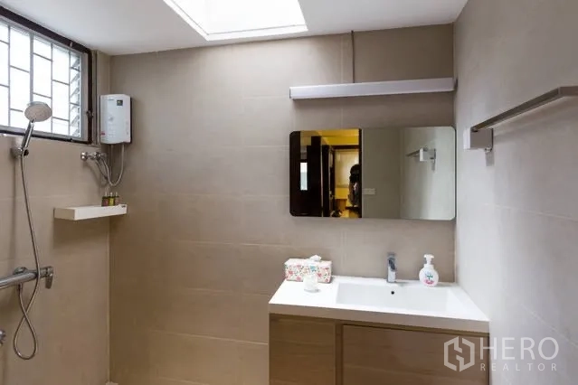 บ้าน ให้เช่าในWatthana, Bangkok - ห้องน้ำสว่าง ผนังสีเบจ เคาน์เตอร์อ่างล้างหน้า ช่องแสงสกายไลท์ และฝักบัวพร้อมเครื่องทำน้ำอุ่น