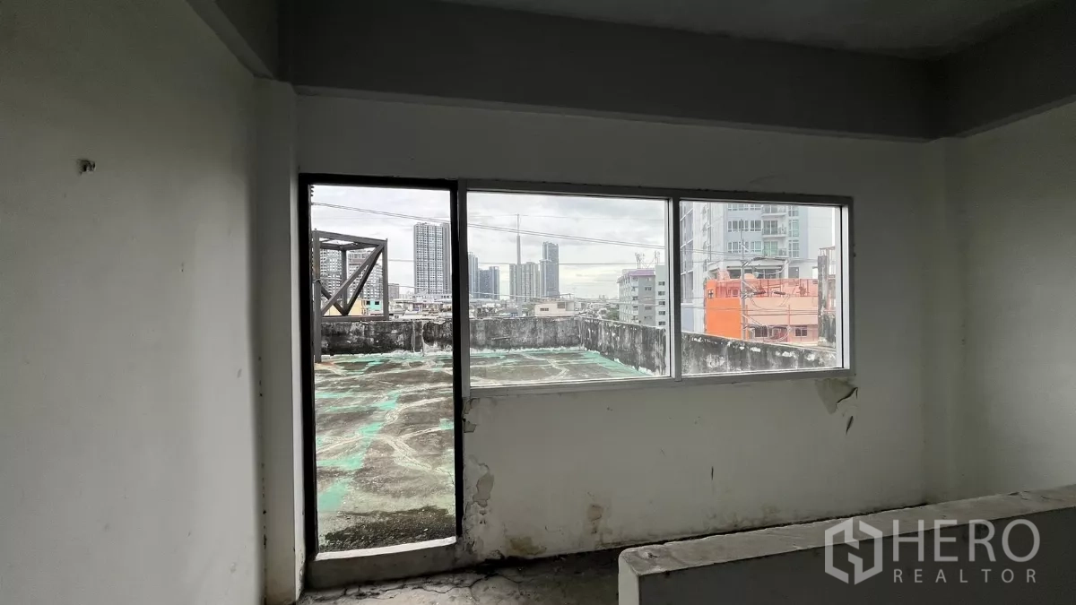 店屋 出租在Watthana, Bangkok - 通往屋顶的房间，宽窗可见城市天际线。