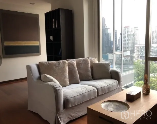 คอนโด ให้เช่าหรือขายในKhlong Toei, Bangkok - ห้องนั่งเล่นสว่างพื้นไม้ โซฟานุ่ม หน้าต่างบานใหญ่เห็นวิวสกายไลน์กรุงเทพฯ