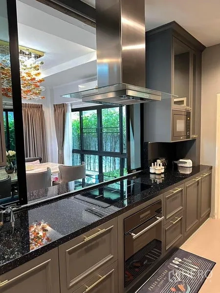 独立式住宅 出租在Prawet, Bangkok - 现代厨房，黑色花岗岩台面、灶台与烟机。