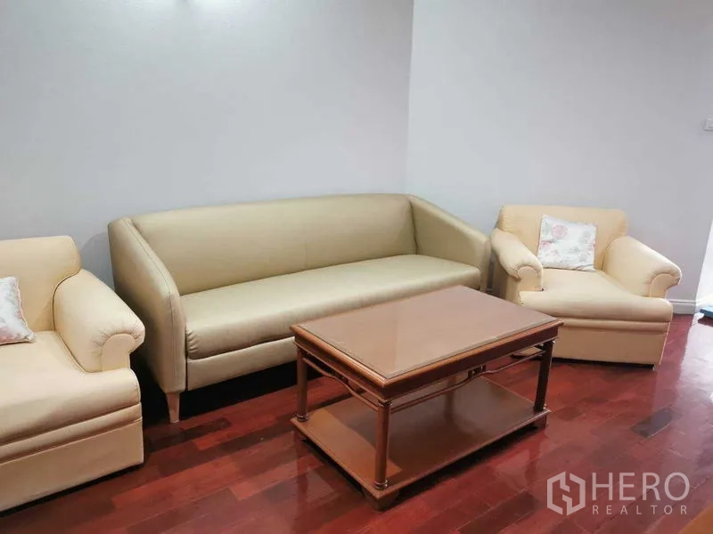 คอนโด ให้เช่า - ชุดโซฟาพร้อมเก้าอี้สองตัวและโต๊ะกลาง บนพื้นไม้